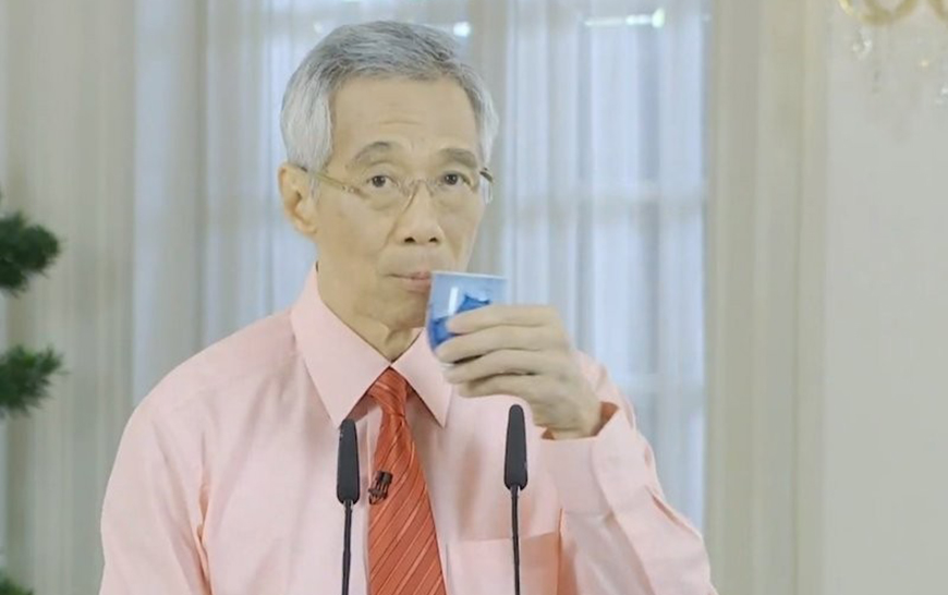 Prime minister Lee of Singapore takes a sip of water during an official announcement